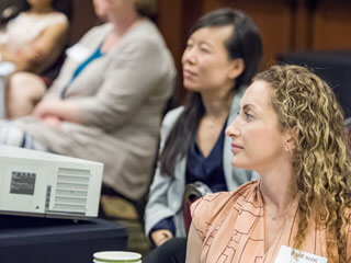 Two young women listening to a presentation